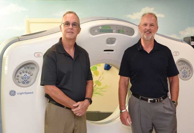 Chambliss brothers standing in front of scanning machine